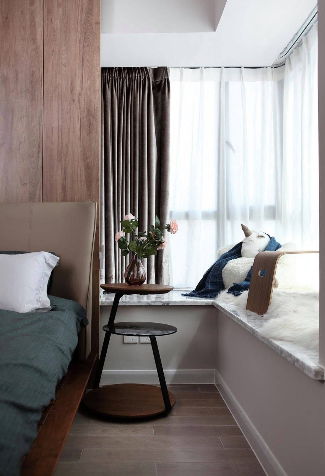 Bedroom bay window seat with marble ledge and sheer curtains